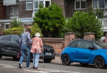 kindness man helping woman across the road